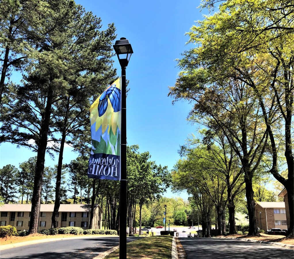 Lamp post with welcome home pendant as you enter Village on Riverwalk apartments in Clayton County rectangle 23